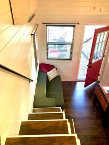 奥斯汀Fox Tiny Home - The Cabins at Rim Rock的一个小房子里的一个楼梯,有绿色的沙发