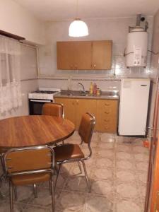 马德普拉塔Casa sur 3 (faro norte)的厨房配有桌椅和冰箱。