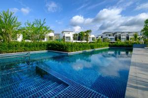 邦涛海滩Laguna Park Villa with rooftop pool by Lofty的房屋前方设有蓝色瓷砖的游泳池