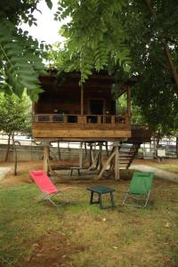 ÇarşıbaşıSaklı Cennet Bungalow & Tatil Köyü的公园里三把椅子和一棵树屋