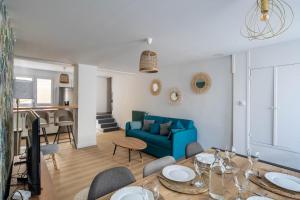 普瓦捷Maison de ville en plein centre avec terrasse的客厅配有蓝色的沙发和桌子