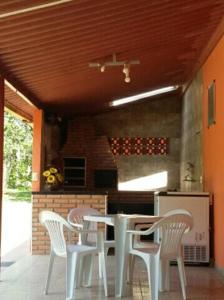 三玛丽亚镇Pousada e Restaurante Maria das Flores的厨房配有白色的桌子和白色的椅子