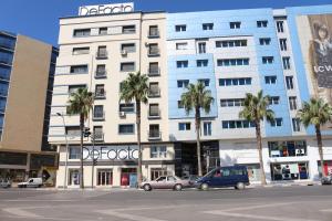 纳祖尔Marchica Apartment Nador Jadid Wifi Klima的一座白色的大建筑,前面有棕榈树