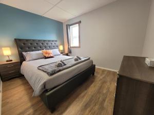 丘吉尔Beluga Beach House的一间卧室设有一张大床,铺有木地板