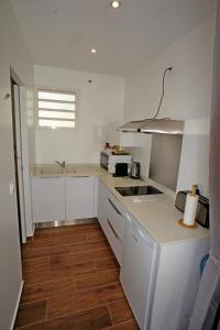 波尔兰特LES HAUTS DE LA BAIE的白色的厨房配有水槽和微波炉