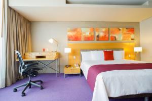 墨西哥城卡米诺里尔圣塔菲酒店的配有一张床和一张书桌的酒店客房