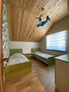 库萨雷Shale Qusar的一间卧室设有两张床和木制天花板