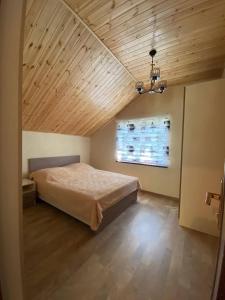 库萨雷Shale Qusar的一间卧室设有一张床和木制天花板