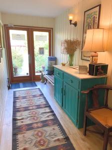 甘奇斯紫藤宾馆的厨房配有绿色橱柜和地毯。