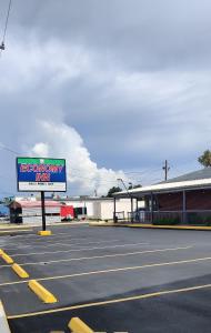 橙县Economy Inn Motel的建筑物前停车场的标志