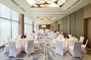 宿务Holiday Inn Cebu City, an IHG Hotel的宴会厅配有白色的桌子和白色的椅子