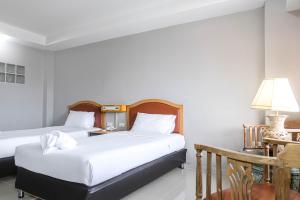 班昌BCP Hotel的一间卧室配有两张床、一张桌子和一盏灯。
