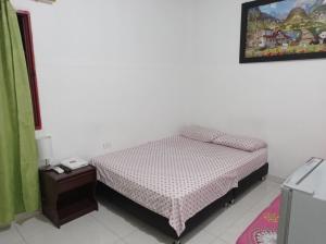 库库塔阿库阿里乌斯酒店的一间小卧室,配有床和床头柜