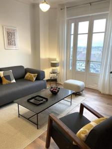 维希Vichy : Le 5e - Appartement design dans un ancien palace的客厅配有沙发和桌子