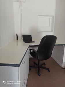 让布卢Loft cosi à proximité du centre géographique Belge的办公室,配有桌椅和笔记本电脑