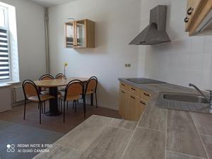 让布卢Loft cosi à proximité du centre géographique Belge的厨房配有桌椅和水槽。