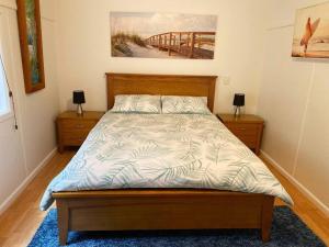 新月岬Crescent Head - Killick Glen - a couple's retreat的卧室内的一张床位,配有两个床头柜和一张四柱床