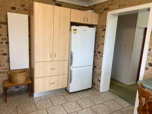 新月岬Crescent Head - Killick Glen - a couple's retreat的厨房配有白色冰箱和木制橱柜。