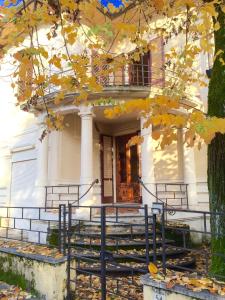 蒙特卡蒂尼泰尔梅普契尼别墅度假屋的一座白色房子,在台阶上放着秋叶
