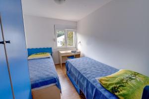 布里尼Apartments by the sea Savar, Dugi otok - 8128的一间小卧室,配有两张床和一张书桌