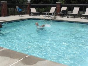 Reidsville里兹维尔智选假日套房酒店 的一个人在游泳池游泳