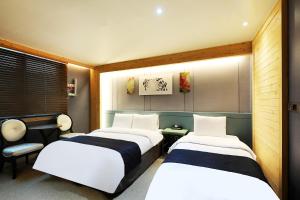 扶安Buan Tourist Hotel的一间带两张床和椅子的房间