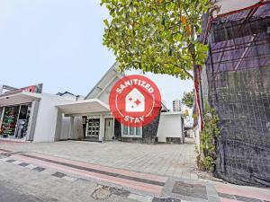 勿里达SUPER OYO 91618 Hotel Nawangwulan的前面有红色标志的建筑