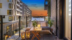 奥斯陆Exclusive apartment, sea view to Oslo fjord, located on water in Oslo center的大楼内的阳台配有桌椅