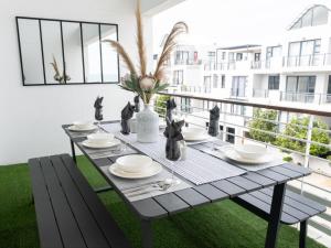 比格湾Azure 213-Luxury 2 Bedroom Apartment with an Inverter & Battery Backup Power的阳台的桌子,享有建筑的景色