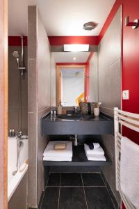 莱斯奥琉斯Résidence Pierre & Vacances Premium les Crets的浴室配有盥洗盆和浴缸。