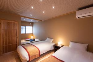 京都宫川町丝蓓绮里恩度假屋的配有两盏灯的小房间内的两张床