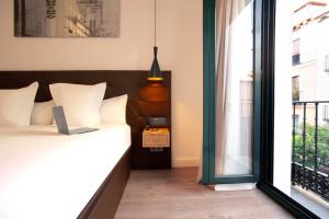 马德里Woohoo Rooms Fuencarral的一间卧室设有一张床和一个窗口