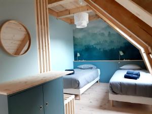 勒蒙多尔Les Burons du Mont-Dore的带两张床和镜子的客房