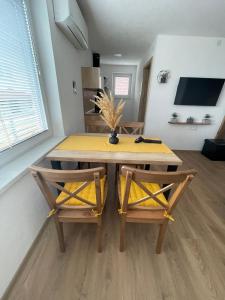 采尔克诺Apartments and rooms pri Bašlju的餐桌、两把椅子和一张黄色桌子