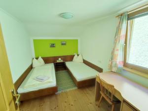 迈尔霍芬Pretty Holiday Home in Mayerhofen with Balcony的客房设有两张床和窗户。