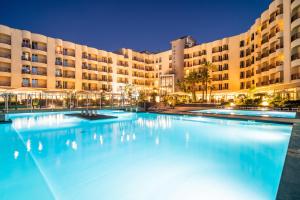 圣夫拉维亚西西里岛多米纳扎戛蕾拉酒店的大型建筑前的大型游泳池