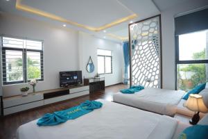 岘港CT HomeStay Da Nang的一间带两张床的卧室和一台电视