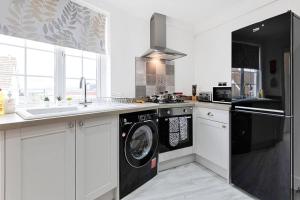 马伯斯3-bed in Mumbles with free parking & sea views的厨房配有洗衣机和水槽