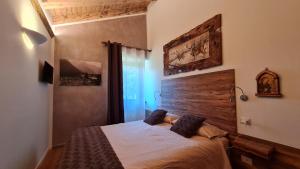 摩德纳迪-坎皮格里奥Masetto的一间卧室配有一张带木制床头板的床
