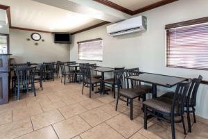 阿马里洛阿马里洛城中央速8酒店的餐厅设有桌椅和墙上的时钟