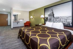 阿马里洛阿马里洛城中央速8酒店的酒店客房设有一张大床,墙上挂着一张大照片