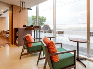 秋田秋田凯富酒店的大堂设有两把椅子和一张桌子,窗户