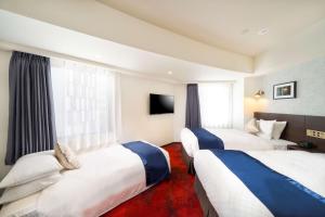 横滨Best Western Hotel Fino Shin-Yokohama的一间酒店客房,设有两张床和电视