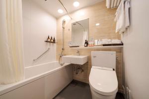 福冈Best Western Plus Fukuoka Tenjin-minami的浴室配有卫生间、盥洗盆和浴缸。