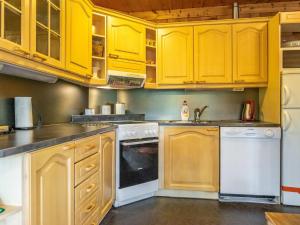 Kangashäkki萨拉维图帕度假屋的厨房配有黄色橱柜和白色家电
