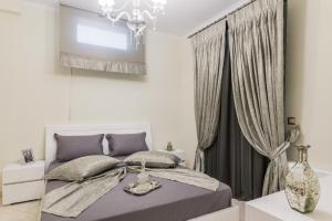 萨摩斯Danae Luxury Apartment的一间卧室配有一张床和一个吊灯