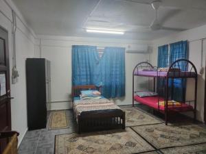 巴佐Homestay Cikgu Yah的客房设有两张双层床和蓝色窗帘。