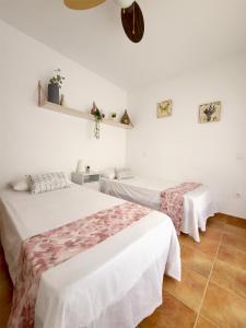 LanzahitaCasa en el valle del tietar的白色墙壁客房的两张床