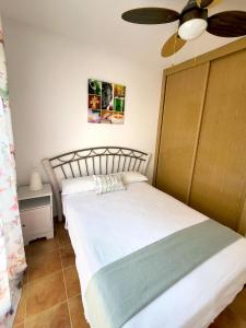 LanzahitaCasa en el valle del tietar的一间卧室配有两张床和吊扇