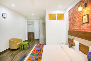 古尔冈FabHotel Aravali Suites的一间卧室设有一张床和砖墙